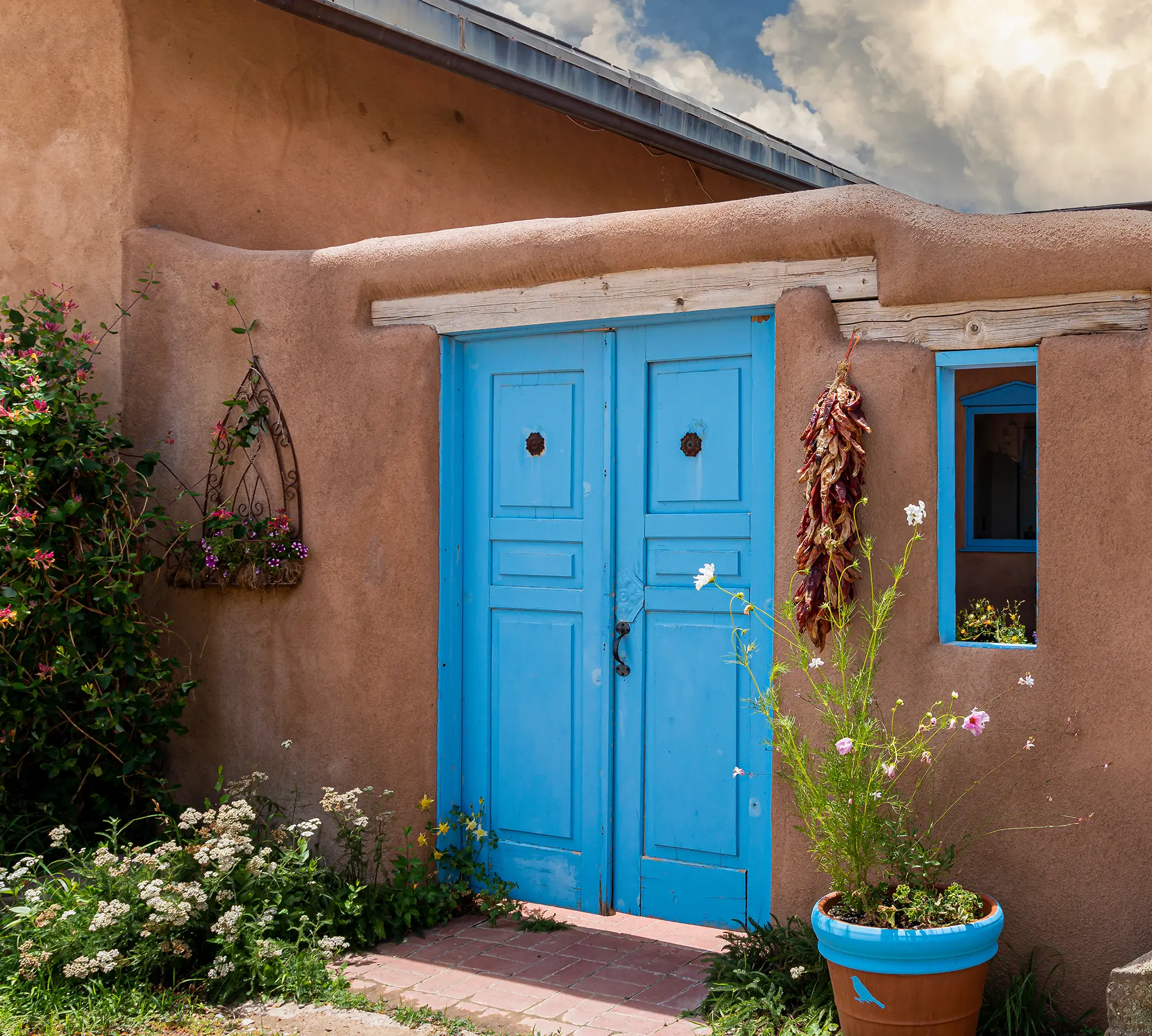 Blue doorway leading into adobe style home